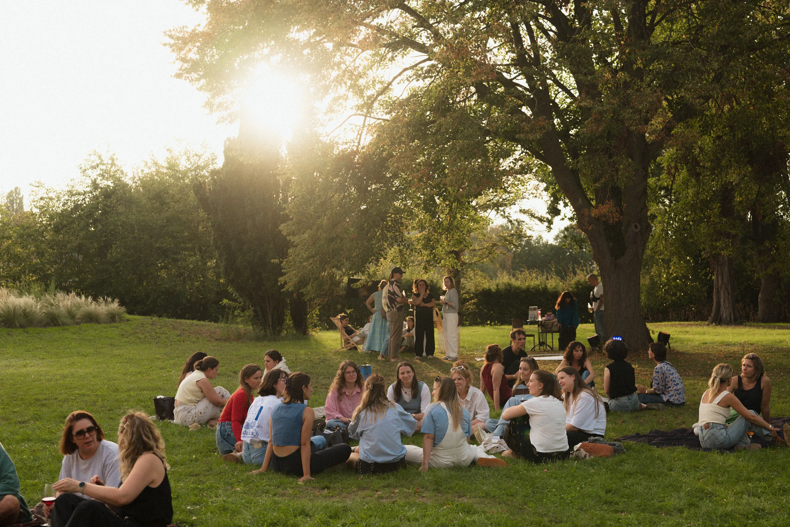 Members samen op het gras in het avondlicht