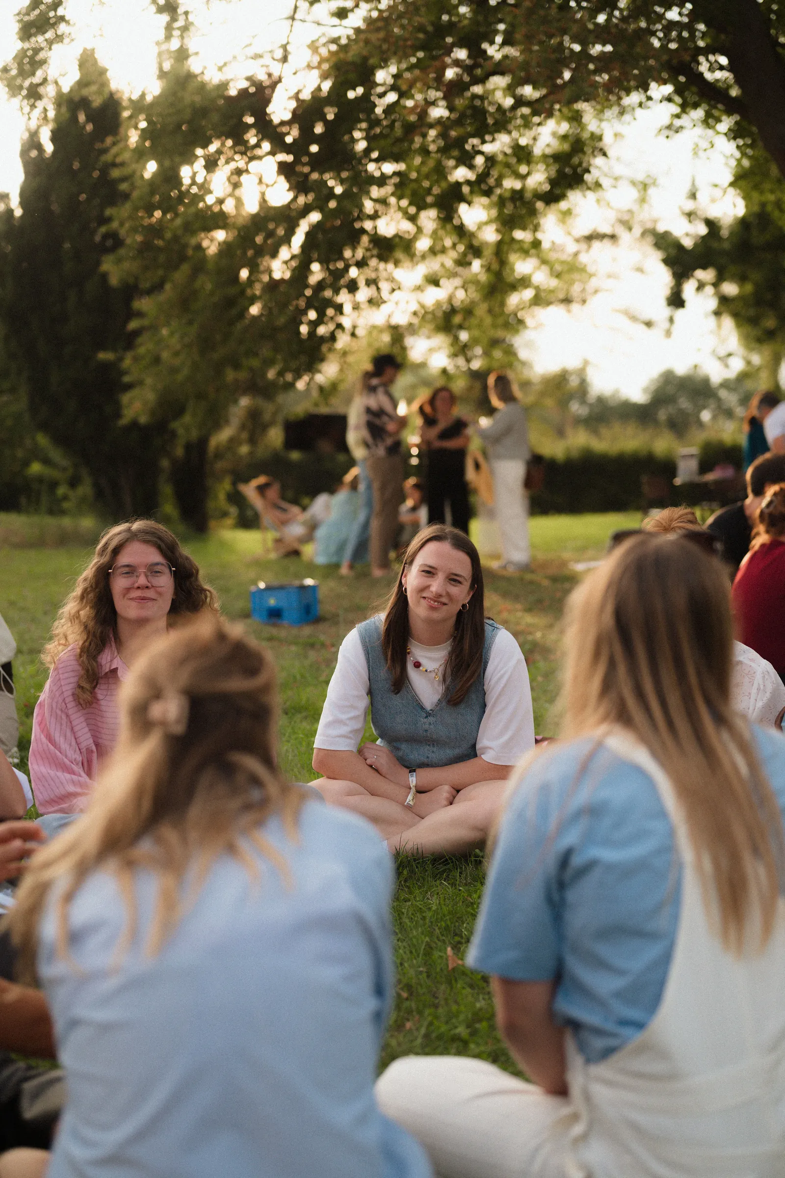 Founders in een kring op het gras in avondlicht tijdens een Ommetoer-dag