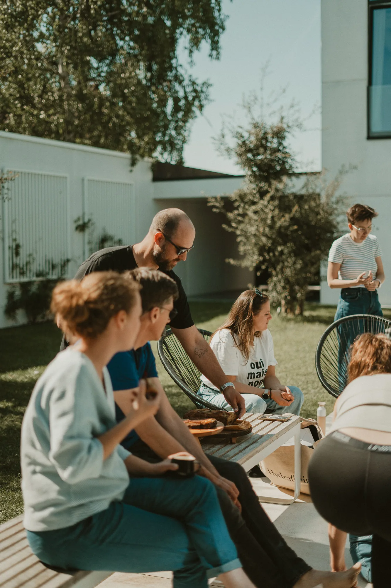 Members rond de picknicktafel in de tuin